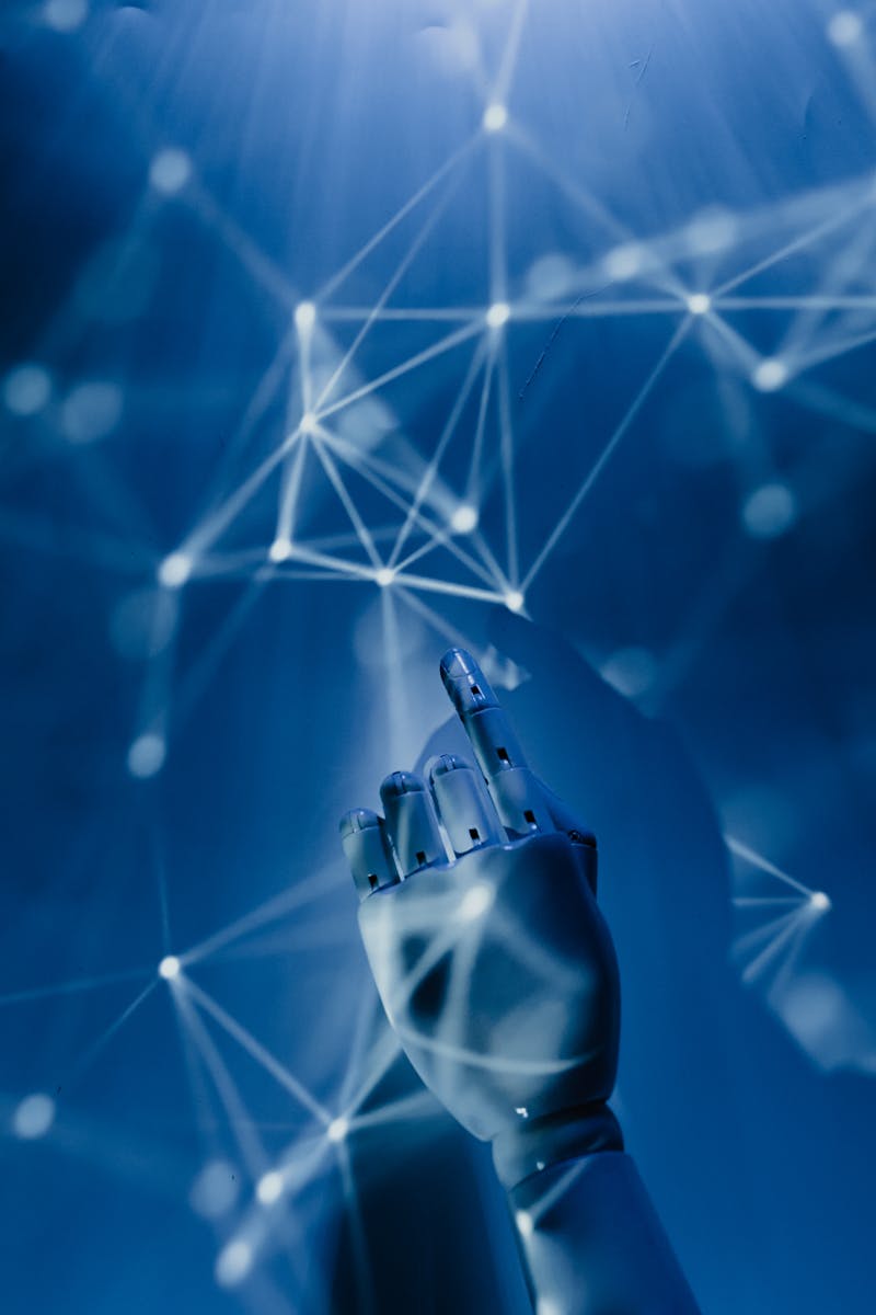 A robotic hand reaching into a digital network on a blue background, symbolizing AI technology.